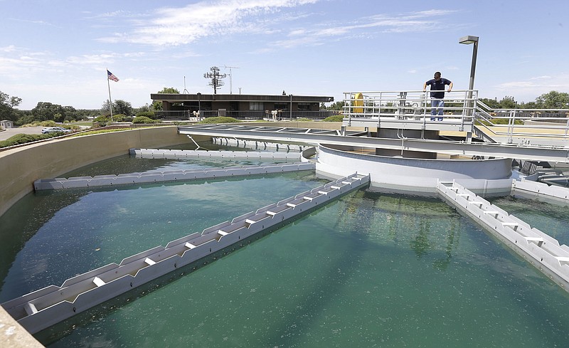 
              In this photo taken Thursday, July 2, 2015, Dan Johnson, a treatment plant operator inspects a sediment pond at the Roseville Water Treatment Plant in Granite Bay, Calif. Due to the reduction of water use, plant operators are using only two of the three sediment ponds that are the first step in preparing the raw water taken from nearby Folsom Lake, for use by Roseville area water users.  Due to the less water use, Roseville is among the water agencies that have had to impose a "drought surcharge," in order to make up the lost revenue.(AP Photo/Rich Pedroncelli)
            