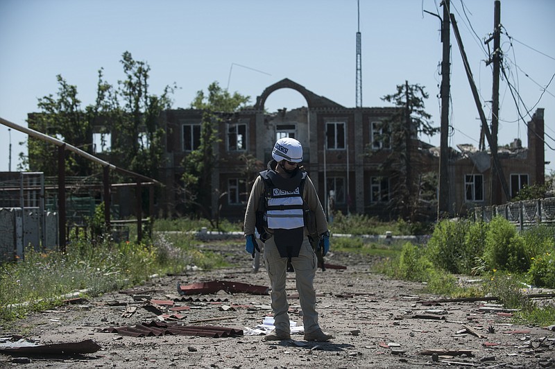
              An OSCE monitor checks the territory for mines during a patrol in Shyrokyne, Donetsk region eastern Ukraine, Saturday, July 4, 2015. (AP Photo)
            