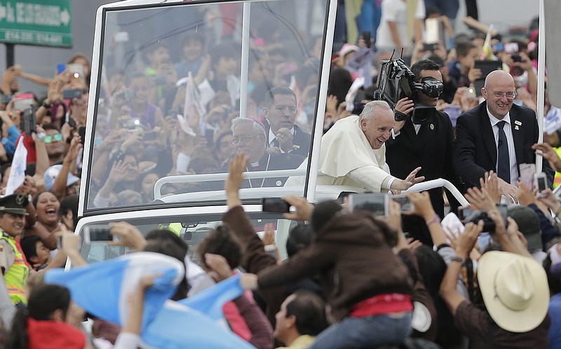 Pope Francis waves to the crowd as he rides aboard the Popemobile in streets of Quito, Ecuador, Sunday, July 5, 2015. 