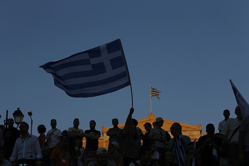 
              Supporters of the No vote wave Greek flags after the referendum's exit polls at Syntagma square in Athens, Sunday, July 5, 2015. Greece faced an uncharted future as officials counted the results of a referendum Sunday on whether to accept creditors' demands for more austerity in exchange for rescue loans, with three opinion polls showing a tight race with a narrow victory likely for the "no" side. (AP Photo/Emilio Morenatti)
            