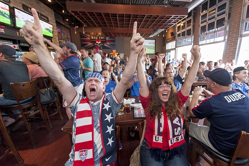 Ted Redilla, left, and Carrie Sills, celebrate while watching the FIFA Women's World Cup soccer championship between the United States and Japan, Sunday, July 5, 2015, from Royal Oak, Mich. (David Guralnick/Detroit News via AP) DETROIT FREE PRESS OUT; HUFFINGTON POST OUT; MANDATORY CREDIT