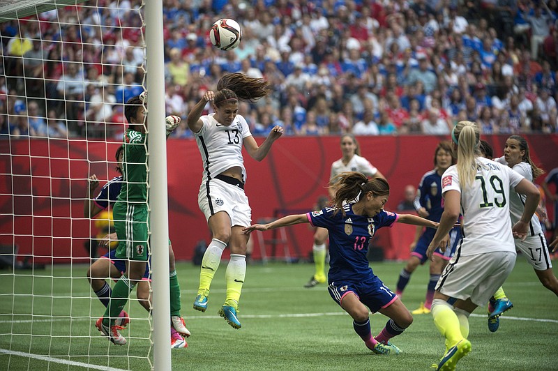 Japan defender Rumi Utsugi (13) goes low as United States' Alex Morgan (13) jumps as a ball from Tobin Heath flies into Japan's net during the FIFA Women's World Cup soccer championship in Vancouver, British Columbia, Canada, Sunday, July 5, 2015. (Jonathan Hayward/The Canadian Press via AP) MANDATORY CREDIT