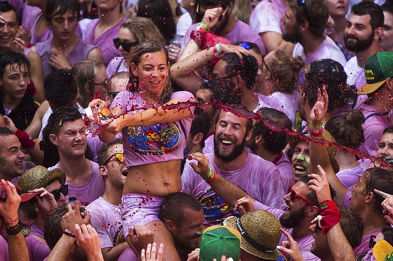 
              A reveler throws wine during the launch of the 'Chupinazo' rocket, to celebrate the official opening of the 2015 San Fermin fiestas in Pamplona, Spain, Monday, July 6, 2015. Revelers from around the world turned out here to kick off the festival with a messy party in the Pamplona town square, one day before the first of eight days of the running of the bulls. (AP Photo/Andres Kudacki)
            