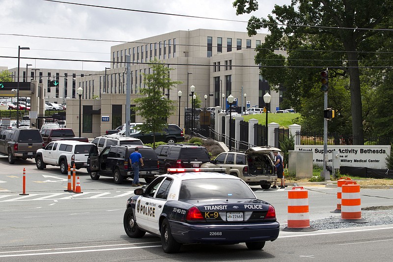 Police officers arrive at the gates of the Walter Reed Medical Center in Bethesda, Md., Monday, July 6, 2015, police say they are checking on a report of a single shot fired at Walter Reed National Military Medical Center outside Washington.