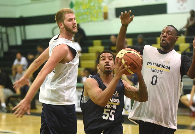 The Servants' Juice Williams takes a shot between AND1's   John Devries and Randall Smith (0) Tuesday evening at Notre Dame High School.

