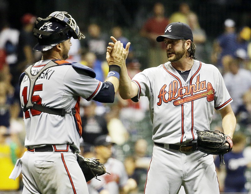 Atlanta Braves relief pitcher Jason Grilli and catcher A.J. Pierzynski celebrate after getting Milwaukee Brewers' Jonathan Lucroy to ground out and end the ninth inning of a baseball game Monday, July 6, 2015, in Milwaukee. The Braves won 5-3.