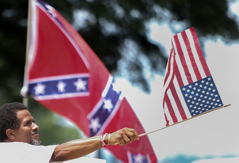 Thomas Wiggins, of Columbia, waves an American Flag while showing support to take the Confederate flag off the South Carolina Statehouse grounds in Columbia, S.C., Tuesday, July 7, 2015. 