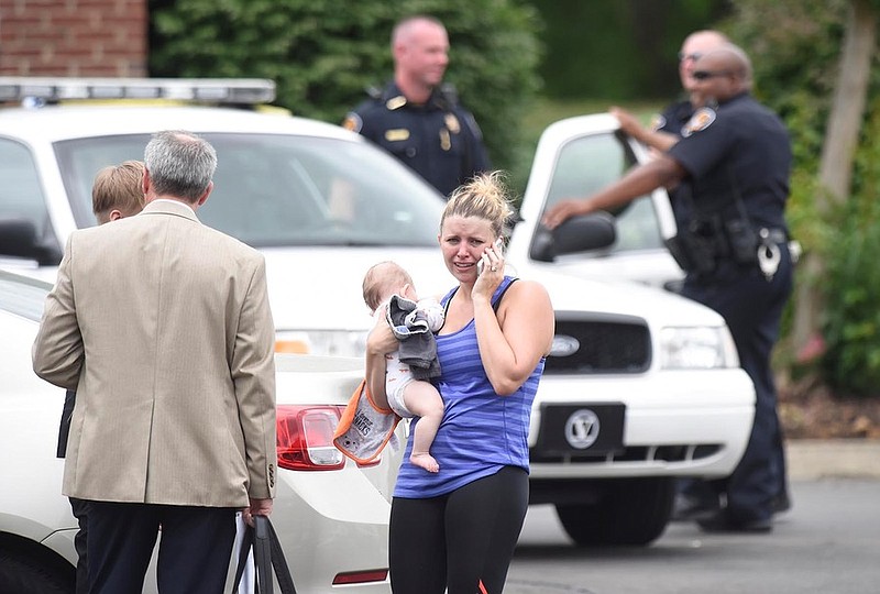 Abbey Harris makes a phone call while cradling her infant outside Knoxville Dermatology Group at 123 Fox Road in Knoxville on Tuesday, July 7, 2015.