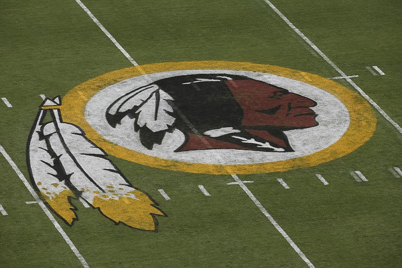 
              FILE - In this Aug. 7, 2014 file photo, the Washington Redskins logo is seen on the field before an NFL football preseason game against the New England Patriots in Landover, Md.  A federal judge has ordered the Patent and Trademark Office to cancel registration of the Washington Redskins' trademark, ruling that the team name may be disparaging to Native Americans. The ruling Wednesday by Judge Gerald Bruce Lee affirms an earlier finding by an administrative appeal board.  (AP Photo/Alex Brandon)
            