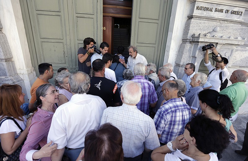 People line up at the main gate of the national bank of Greece as they wait to withdraw a maximum of 120 euros ($134) for the week in central Athens, Greece, on Wednesday. Greece is scrambling to develop a detailed proposal to move away from the brink of financial collapse.