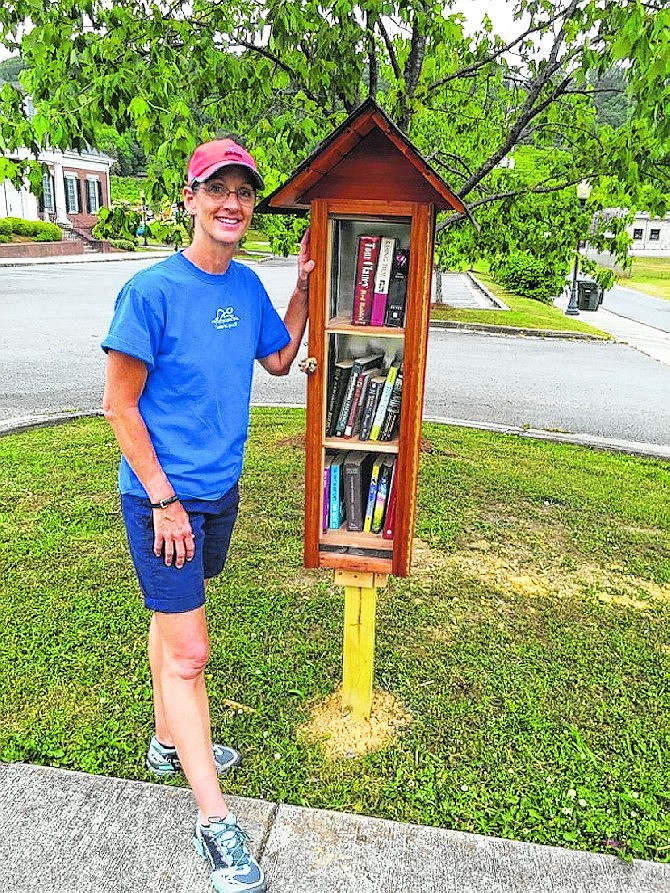 Jill Richmond stands beside a birdhouse shaped Little Free Library in front of Ringgold City Hall.