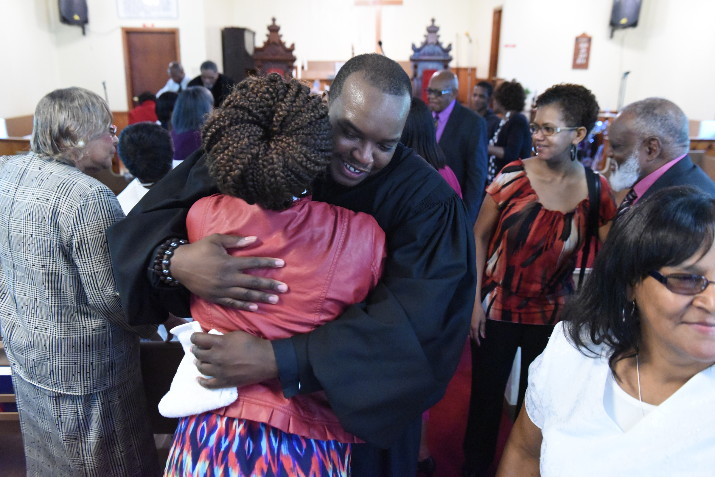 Rev. Solomon Missouri hugs a church member after a worship service at Hemphill African Methodist Episcopal Zion Church on Sunday in Summerville, Ga.