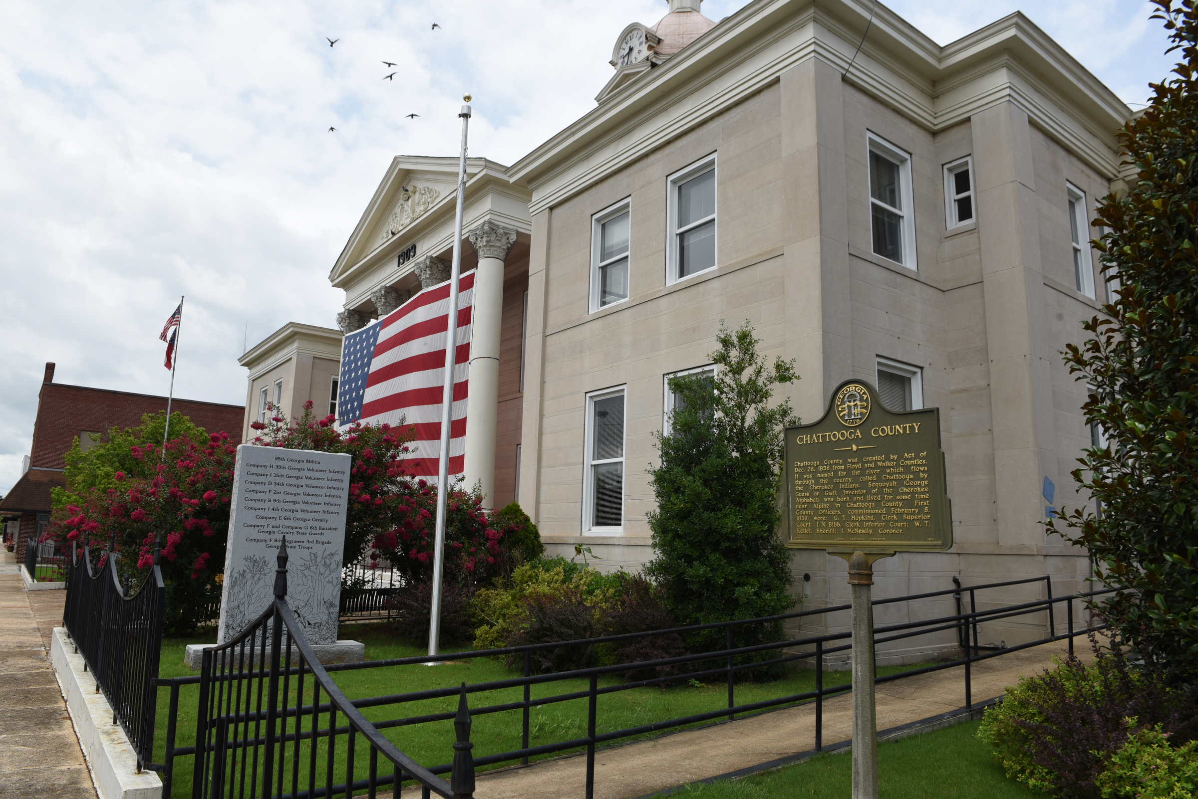 The Confederate flag has been taken down from a flagpole next to a Confederate monument seen in the foreground on the front lawn of the Chattooga County Courthouse on Sunday in Summerville, Ga.