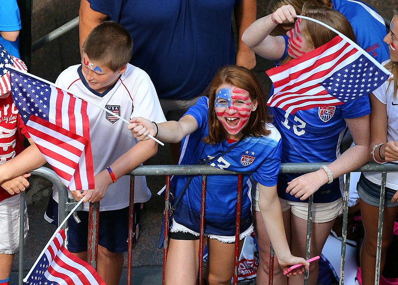 A young fan cheers while waiting for the ticker tape parade to celebrate the U.S. women's soccer team World Cup victory on July 10, 2015, in New York. 