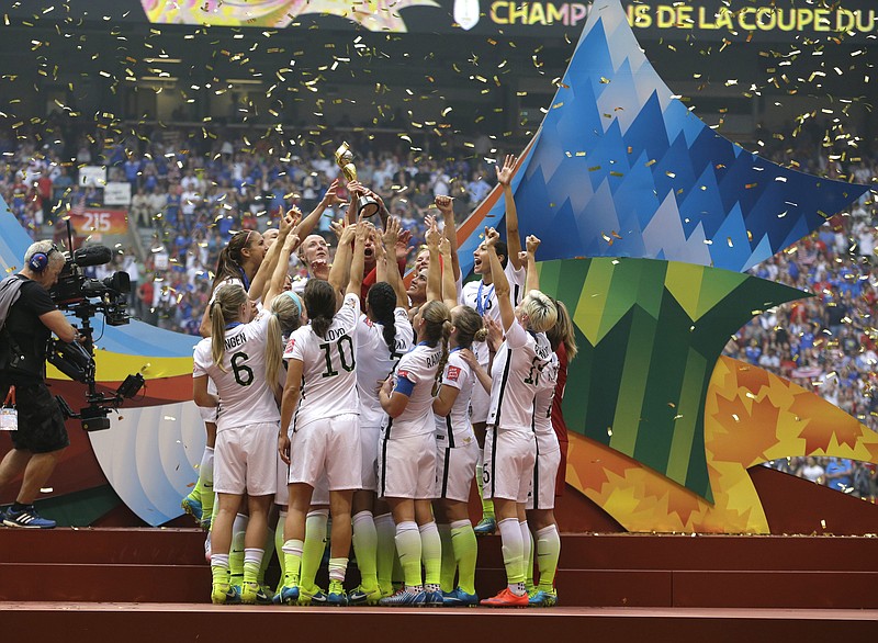 Confetti floats down as the United States Women's National Team women celebrate with their trophy after beating Japan 5-2 in the FIFA Women's World Cup soccer championship in Vancouver, Canada, in this July 5, 2015 file photo.
