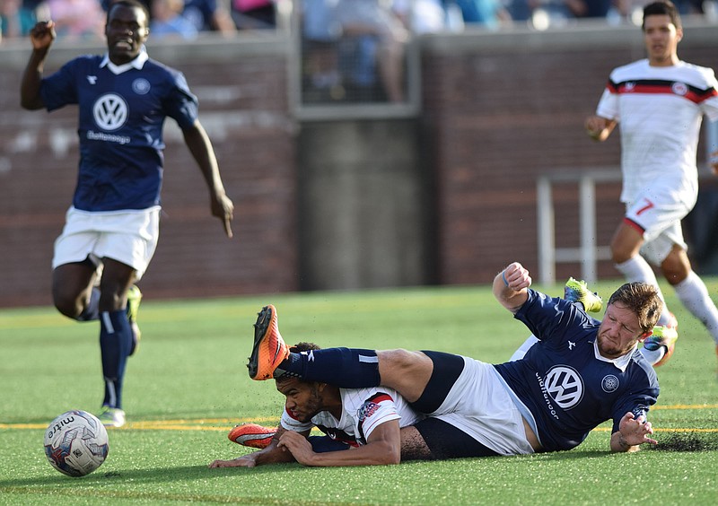 Chattanooga's Luke Winter (17) shoves the ball forward as his taken down by a Atlanta defenseman.  The Chattanooga FC hosted the Atlanta Silverbacks Reserves in the championship of the Southeast Conference at Finley Stadium Saturday, July 11, 2015.