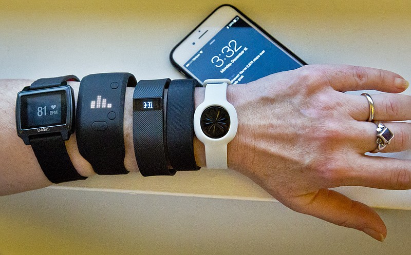 
              FILE - In this Dec. 15, 2014, file photo, fitness trackers, from left, Basis Peak, Adidas Fit Smart, Fitbit Charge, Sony SmartBand, and Jawbone Move, are posed for a photo next to an iPhone, in New York. Although sales of fitness trackers are strong, many of their owners lose enthusiasm for them once the novelty wears off. (AP Photo/Bebeto Matthews, File)
            