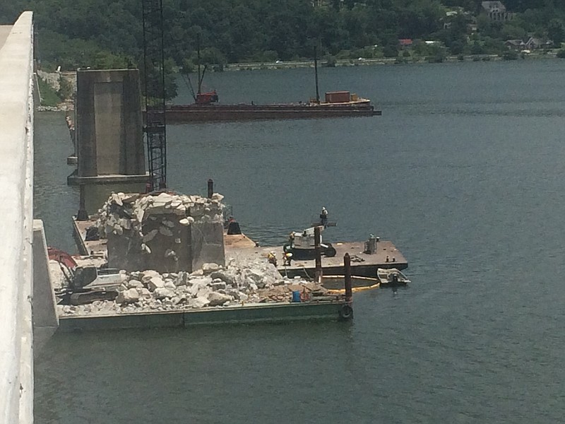 This photograph taken by Tennessee Department of Transportation officials shows concrete bridge debris piled on a barge on the Tennessee River where concrete piers are being reduced to rubble by pieces of heavy equipment. TDOT officials say the contractor has permission to leave demolition debris from the piers in the lake as long as standards are met.