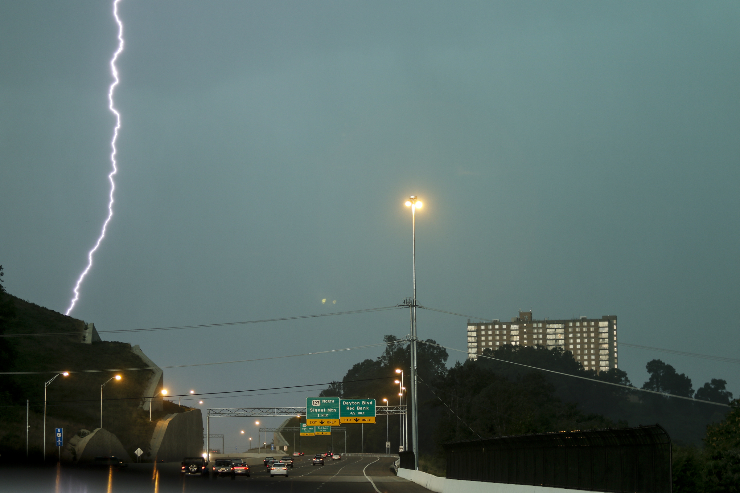 Lightning strikes over the crest of the hill leading away from downtown along U.S. Highway 27 northbound as thunderstorms reach the area Tuesday, July 14, 2015, in Chattanooga, Tenn.