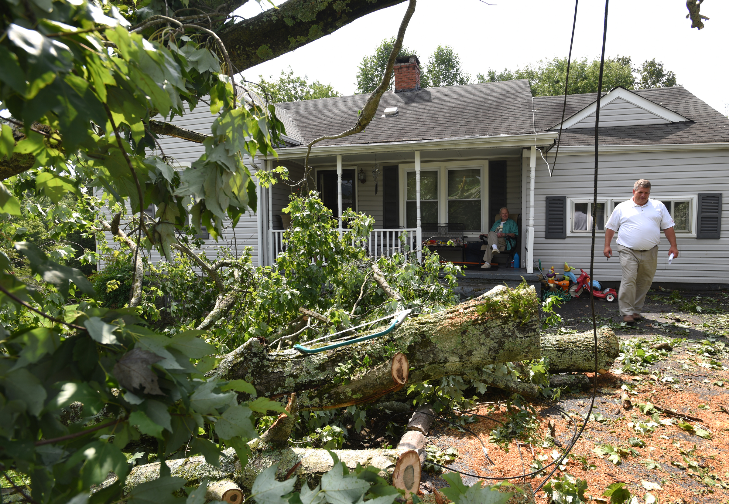 Ken Wallace, right, with Farm Bureau insurance, leaves George and Dorothy Wyatt's Lynda Drive home in Red Bank Wednesday, July 15, 2015 after storms came through the area Tuesday.
