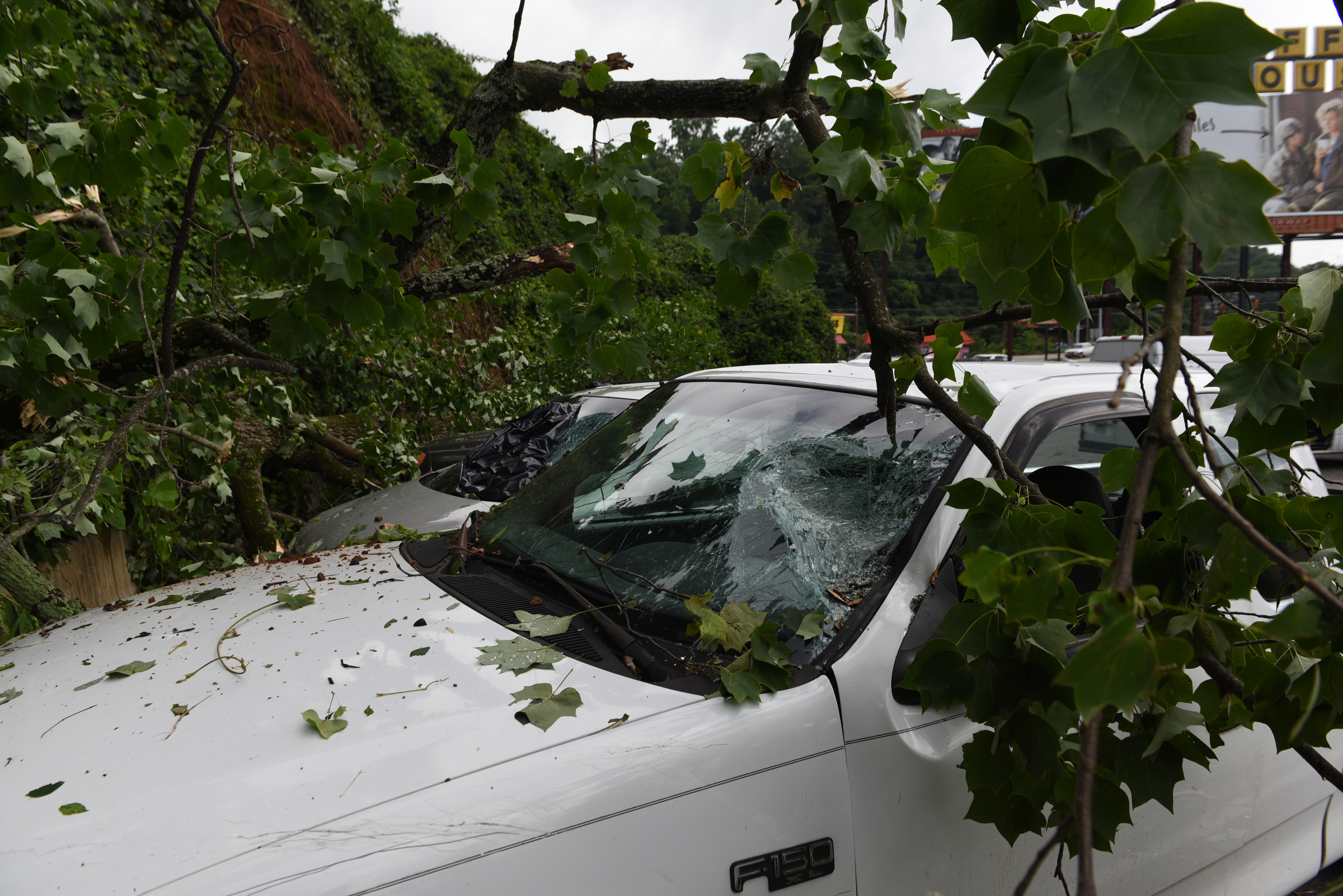 Damaged vehicles and downed trees are seen in the parking lot of Sofa King Juicy Burgers on Wednesday, July 15, 2015, in Red Bank, Tenn. A strong line of Tuesday evening thunderstorms caused storm damage in various parts of the Chattanooga area.