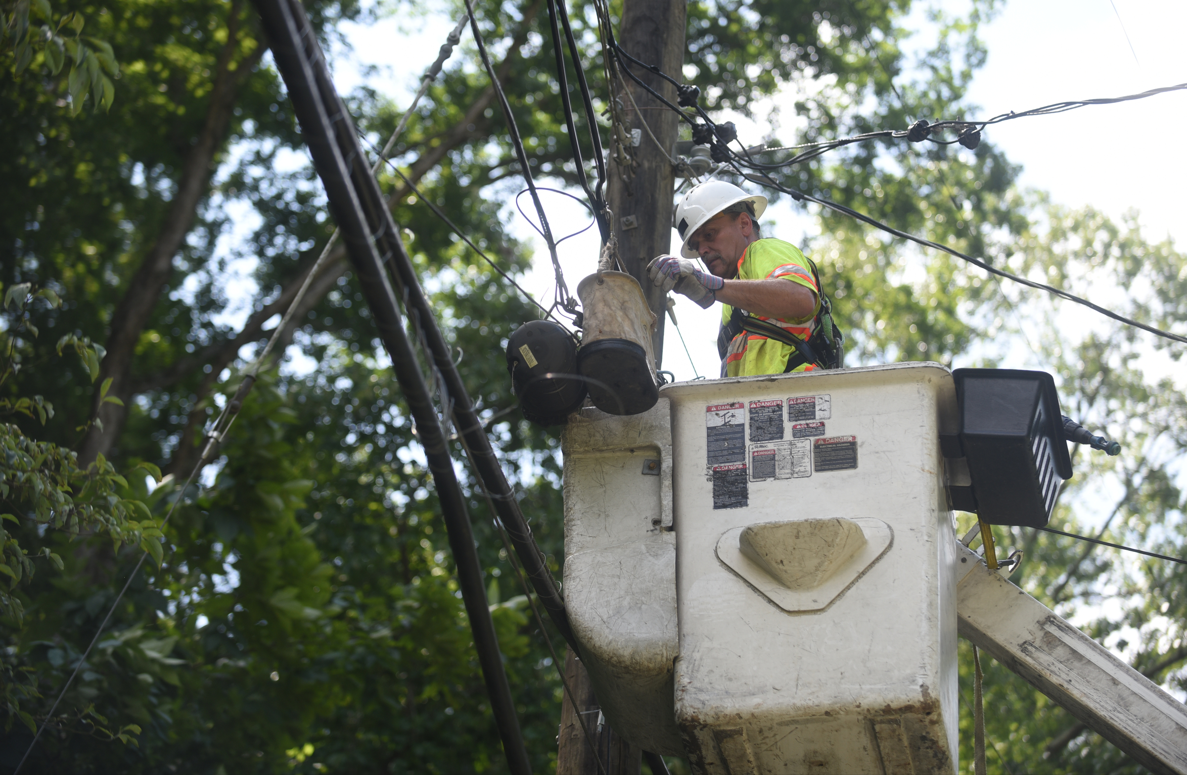 Wayne Cooke, with GaddCom, repairs Comcast lines on Hedgewood Drive in Red Bank Wednesday, July 15, 2015 after storms came through the area Tuesday.