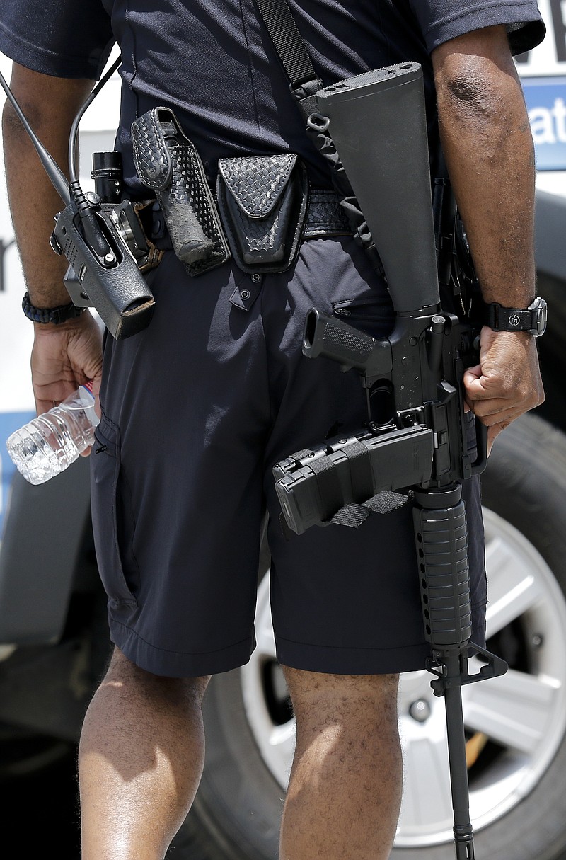 A Hamilton County Sheriff's officer carries a rifle out of Erlanger Hospital's emergency room when the lockdown is ended after a shooting at both the Amnicola Highway Armed Forces Career Center and the Naval Operational Support Center on Amnicola Highway on Thursday, July 16, 2015, in Chattanooga. The shooting left five dead, including the shooter, and a Chattanooga police officer wounded.