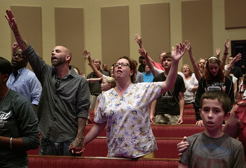 Greg, left, and Leslie Walker hold hands during a prayer vigil at Redemption Point Church on Thursday, July 16, 2015, in Chattanooga, Tenn. The vigil followed a shooting at both the Lee Highway Armed Forces Career Center and the Naval Operational Support Center on Amnicola Highway which left five dead, including the shooter, and a Chattanooga police officer wounded.