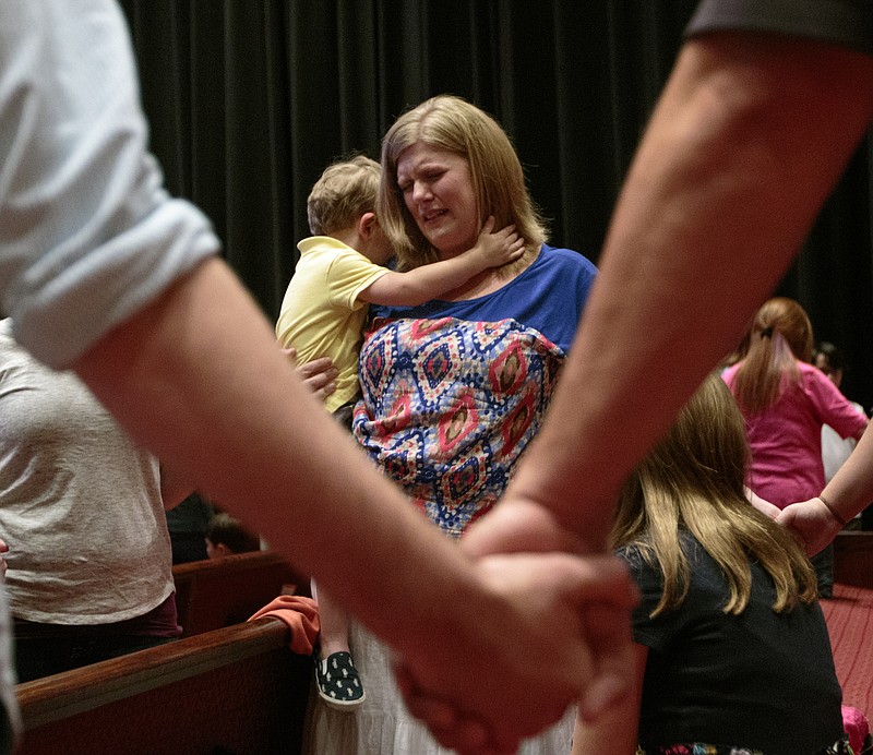 Stephanie Rhoades holds her son Peyton during a prayer vigil at Redemption Point Church on Thursday, July 16, 2015, in Chattanooga, Tenn. The vigil followed a shooting at both the Lee Highway Armed Forces Career Center and the Naval Operational Support Center on Amnicola Highway which left five dead, including the shooter, and a Chattanooga police officer wounded.