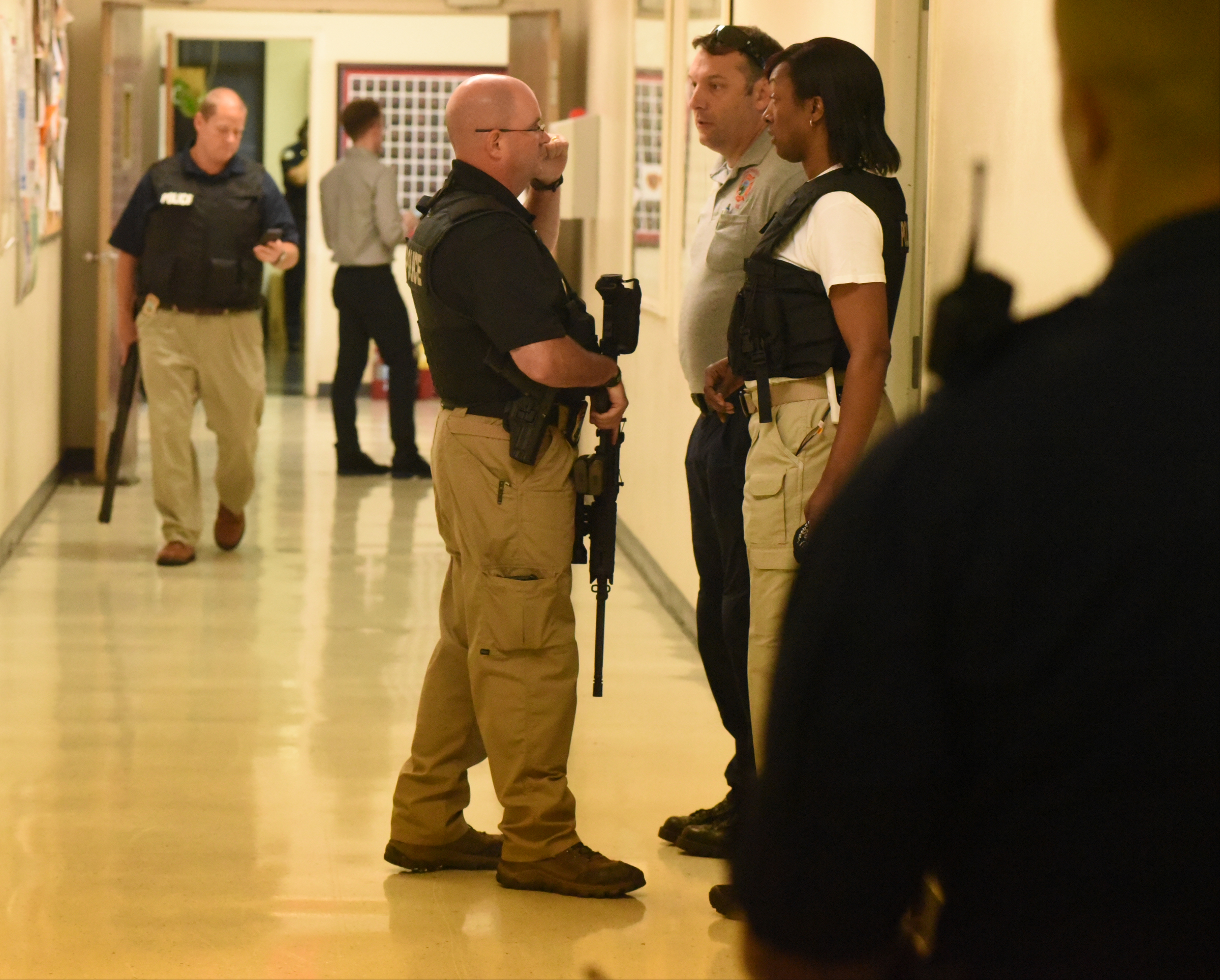 Chattanooga Police Department Sgt. John Monroe, center, holds an automatic weapon prior to a news conference at the Chattanooga Fire Training center about a domestic terror incident that killed four Marines at the nearby Naval Reserve facility on Amnicola Highway on Thursday, July 16, 2015, in Chattanooga, Tenn.