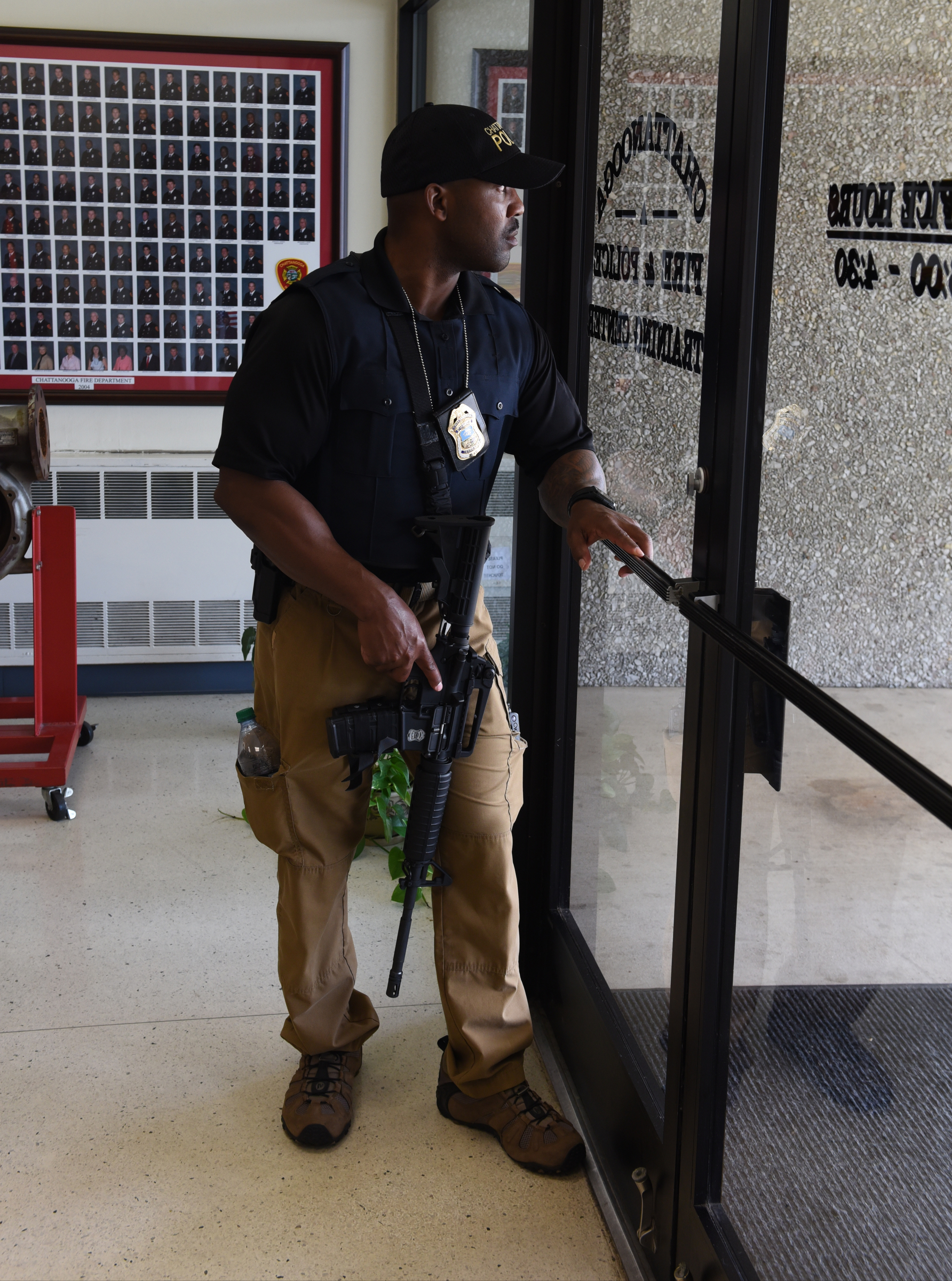 Chattanooga Police Department instructor Ricky Ballard guards the front door at the Chattanooga Fire Training center prior to a news conference about a domestic terror incident that killed four Marines at the nearby Naval Reserve facility on Amnicola Highway on Thursday, July 16, 2015, in Chattanooga, Tenn.
