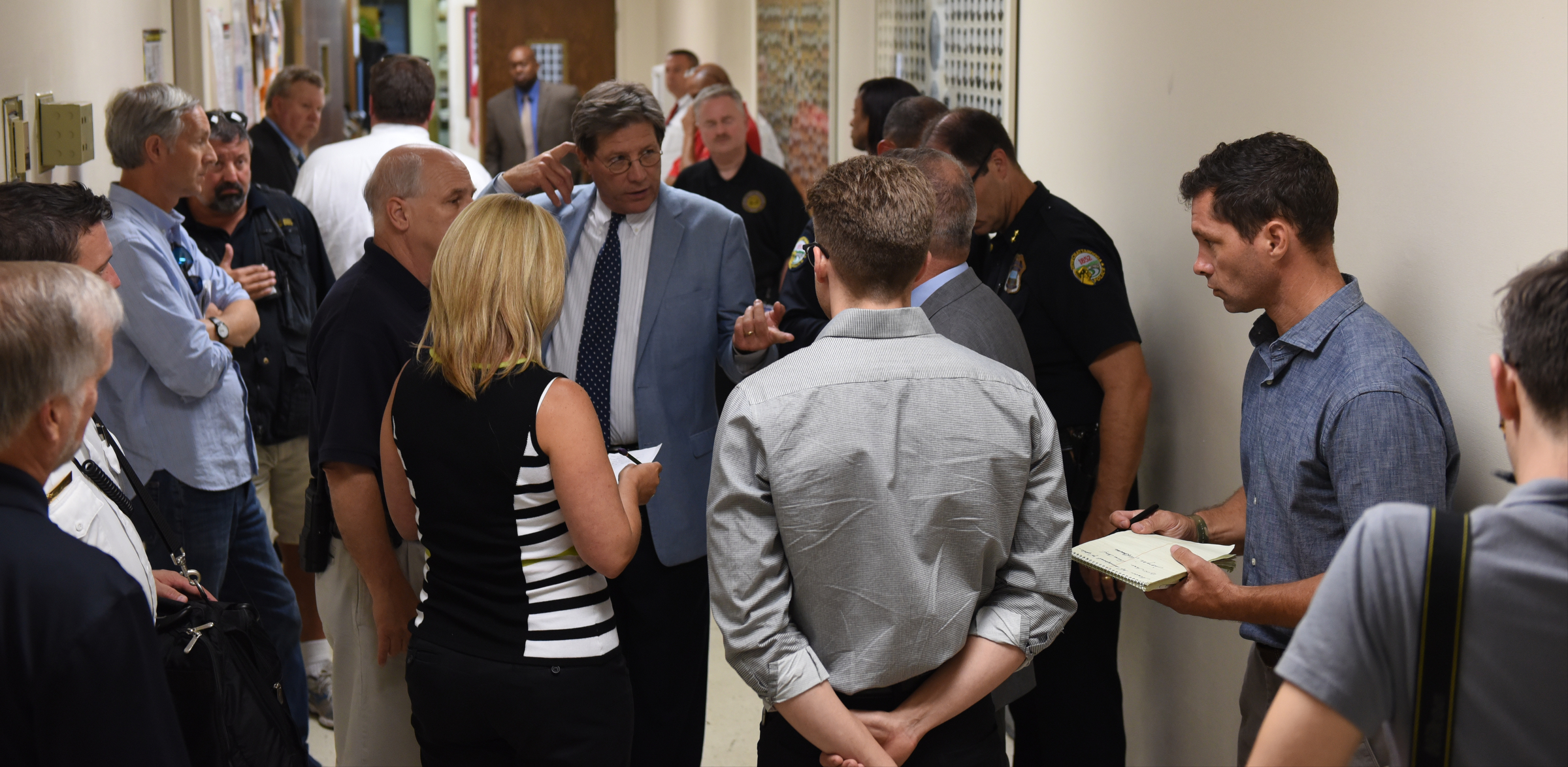 U. S. District Attorney General Bill Killian, center, speaks with others in a hallway after a news conference at the Chattanooga Fire Training center about a domestic terror incident that killed four Marines at the Naval Reserve facility on Amnicola Highway on Thursday, July 16, 2015, in Chattanooga, Tenn.