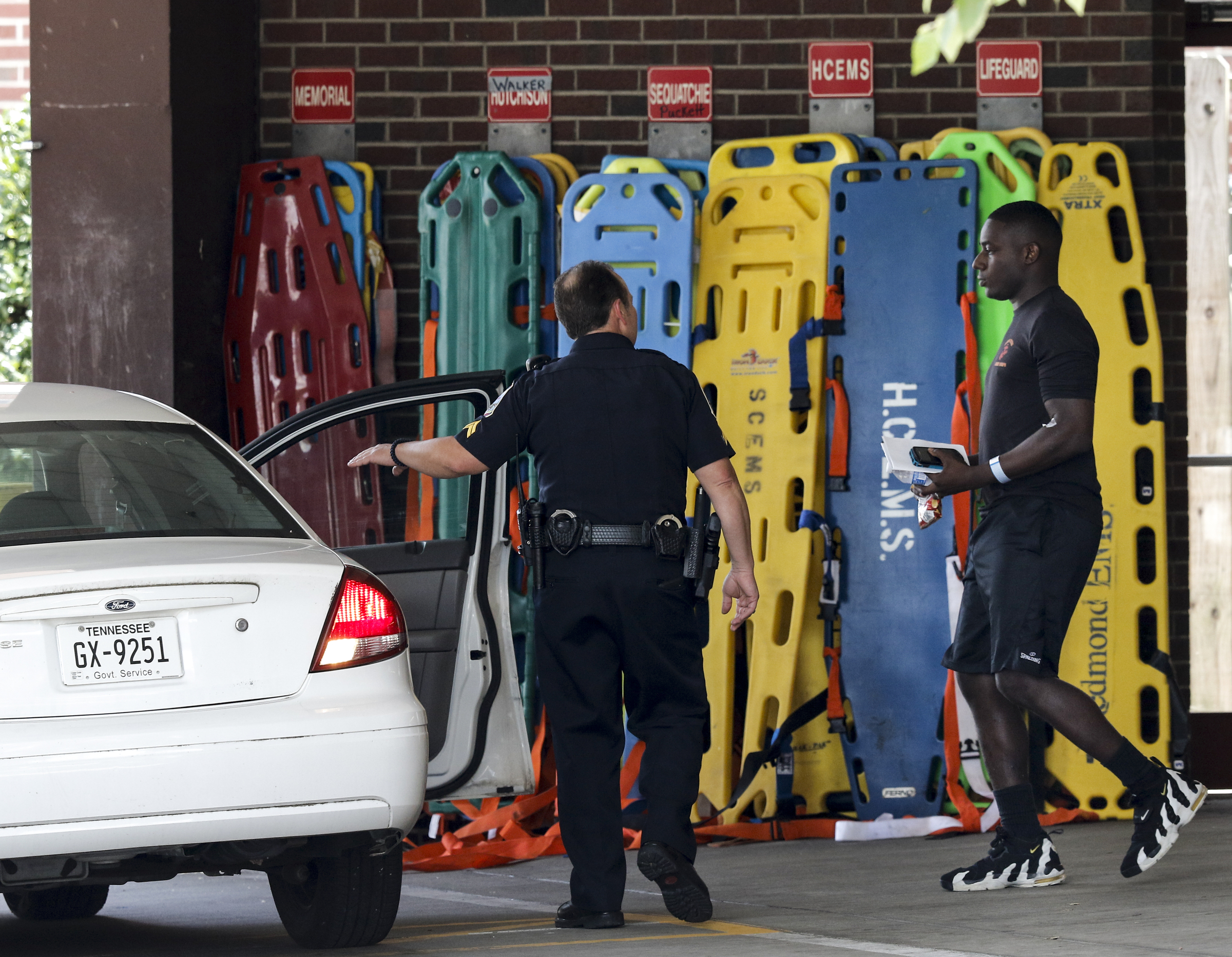 Sgt. DeMonte Cheeley limps as he is escorted to an unmarked patrol car by police officers from Erlanger Hospital's emergency room after a shooting at both the Lee Highway Armed Forces Career Center and the Naval Operational Support Center on Amnicola Highway on Thursday, July 16, 2015, in Chattanooga, Tenn. The shooting left five dead, including the shooter, and a Chattanooga police officer wounded.