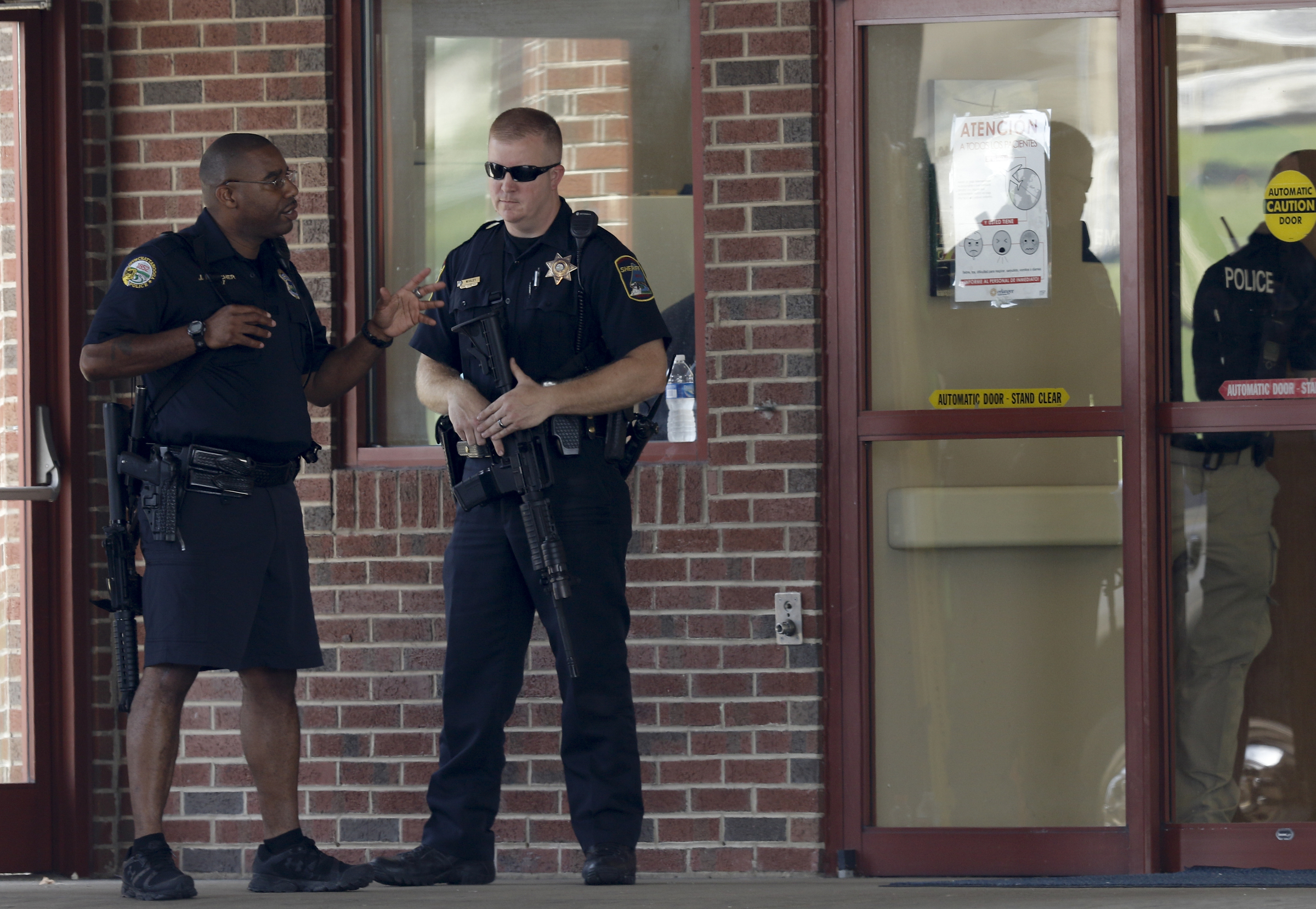 Hamilton County Sheriff's officers hold rifles outside of Erlanger Hospital's emergency room while the hospital is on lockdown after a shooting at both the Amnicola Highway Armed Forces Career Center and the Naval Operational Support Center on Amnicola Highway on Thursday, July 16, 2015, in Chattanooga, Tenn. The shooting left five dead, including the shooter, and a Chattanooga police officer wounded.