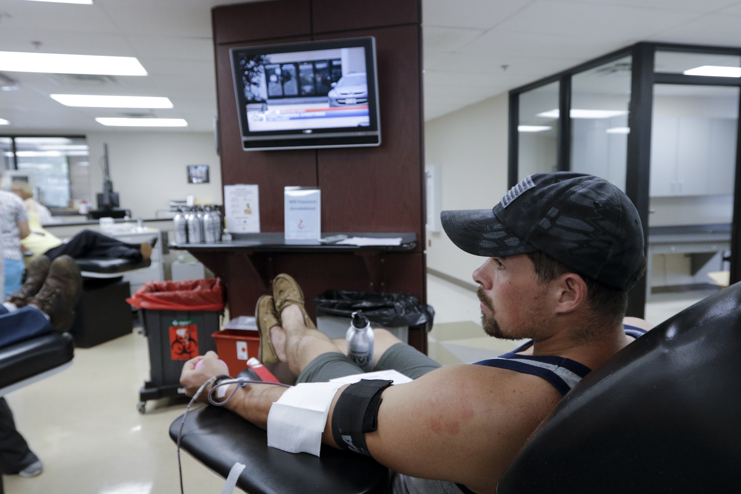 Retired marine Ben Cool watches news reports as he donates blood at the Blood Assurance center Thursday, July 116, 2015, in Chattanooga, Tenn. Cool came to donate blood after hearing about the shooting at both the Lee Highway Armed Forces Career Center and the Naval Operational Support Center on Amnicola Highway which left five dead, including the shooter, and a Chattanooga police officer wounded.