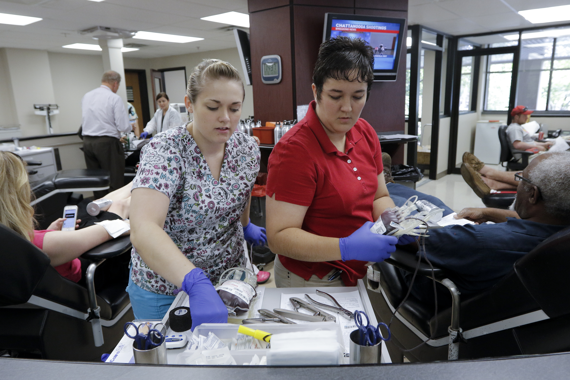 Phlebotomists Katrice Davenport, left, and Lauren Hinton prepare bags of donated blood at Blood Assurance after a shooting at both the Amnicola Highway Armed Forces Career Center and the Naval Operational Support Center on Amnicola Highway on Thursday, July 16, 2015, in Chattanooga, Tenn. The shooting left five dead, including the shooter, and a Chattanooga police officer wounded.