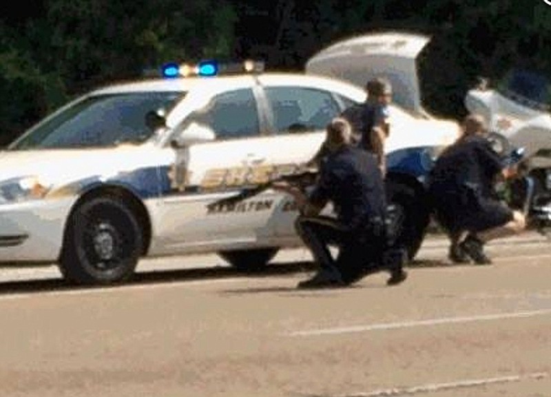 In this image made from video and released by WRCB-TV, authorities work an active shooting scene on amincola highway near the Naval Reserve Center, in Chattanooga. on Thursday, July 16, 2015. Chattanooga Mayor Andy Berke says police are pursuing an active shooter after reports of a shooting at the military reserve center. (WRCB-TV via AP) MANDATORY CREDIT