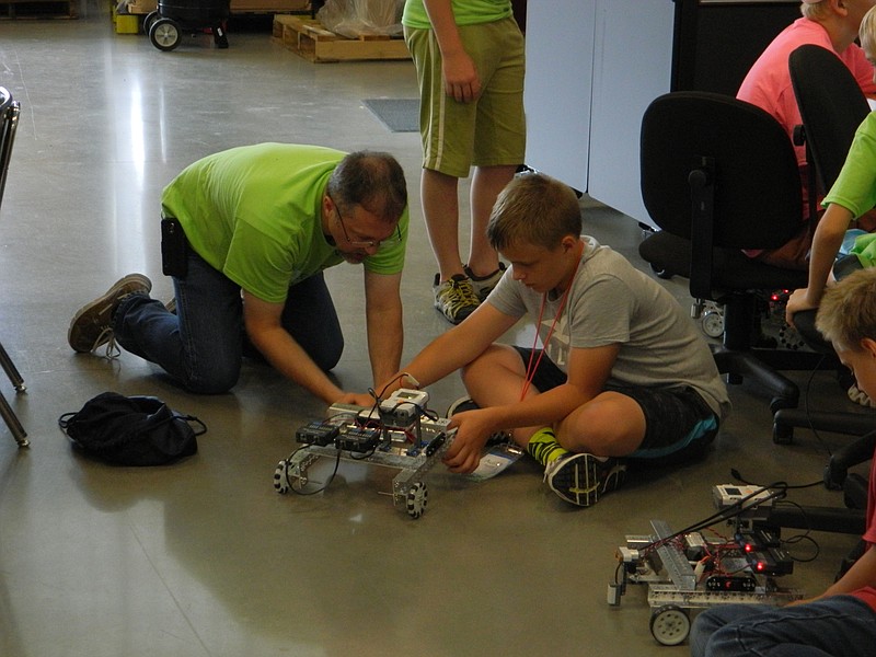 Instructor Ray Ledford, left, assists Austin Pettit with making some adjustments to his project in Advanced LEGO robotics, one of several STEM (Science, Technology, Engineering and Math) camps hosted by Cleveland State Community College this summer.
