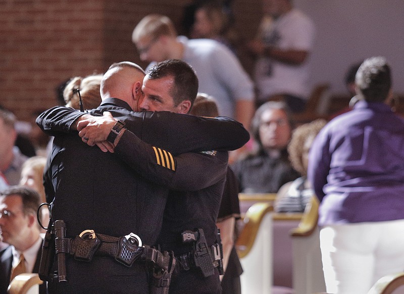 Chattanooga Deputy Police Chief David Roddy, right, hugs Sgt. Denny Jones before an interfaith vigil at Olivet Baptist Church held in remembrance of victims of the July, 16 shootings on Friday, July 17, 2015, in Chattanooga, Tenn. The vigil was held one day after gunman Mohammad Youssef Abdulazeez shot and killed four U.S. Marines and wounded two others and a Chattanooga police officer at the Naval Operational Support Center on Amnicola Highway shortly after firing into the Armed Forces Career Center on Lee Highway.