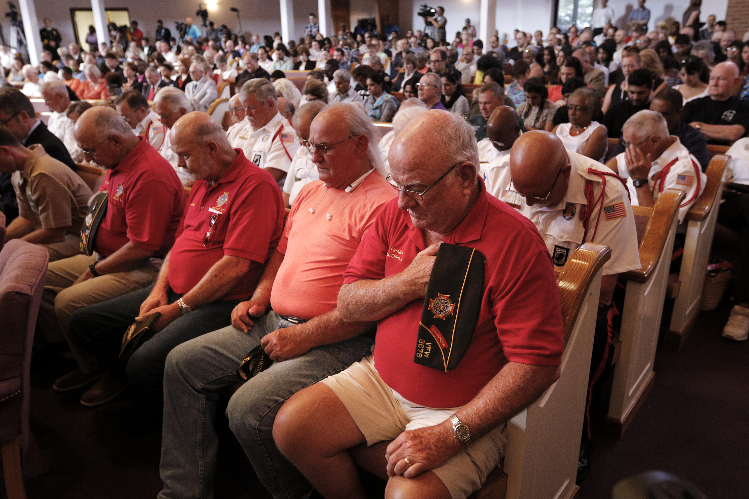 Supporters bow their heads in prayer for the start of an interfaith vigil at Olivet Baptist Church held in remembrance of victims of the July, 16 shootings on Friday, July 17, 2015, in Chattanooga, Tenn. The vigil was held one day after gunman Mohammad Youssef Abdulazeez shot and killed four U.S. Marines and wounded two others and a Chattanooga police officer at the Naval Operational Support Center on Amnicola Highway shortly after firing into the Armed Forces Career Center on Lee Highway.