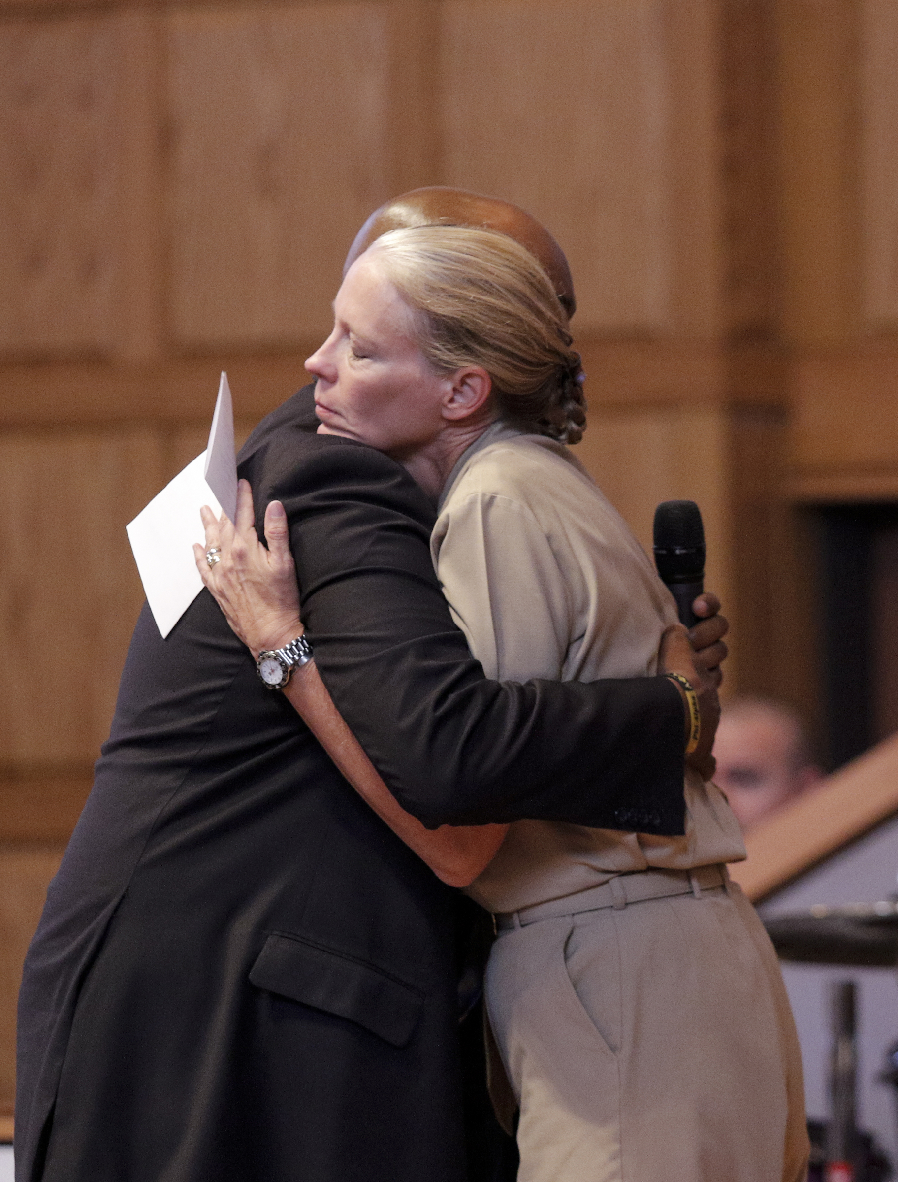 Chattanooga Public Safety Coordinator Paul Smith, left, hugs U.S. Navy Rear Admiral Mary Jackson before she speaks at an interfaith vigil at Olivet Baptist Church held in remembrance of victims of the July, 16 shootings on Friday, July 17, 2015, in Chattanooga, Tenn. The vigil was held one day after gunman Mohammad Youssef Abdulazeez shot and killed four U.S. Marines and wounded two others and a Chattanooga police officer at the Naval Operational Support Center on Amnicola Highway shortly after firing into the Armed Forces Career Center on Lee Highway.