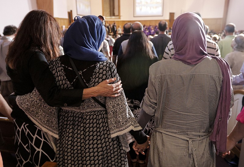 Women who came with others from the Islamic Society of Greater Chattanooga to offer their support put their hands around one another during an interfaith vigil at Olivet Baptist Church held in remembrance of victims of the July, 16 shootings on Friday, July 17, 2015, in Chattanooga, Tenn. The vigil was held one day after gunman Mohammad Youssef Abdulazeez shot and killed four U.S. Marines and wounded two others and a Chattanooga police officer at the Naval Operational Support Center on Amnicola Highway shortly after firing into the Armed Forces Career Center on Lee Highway.