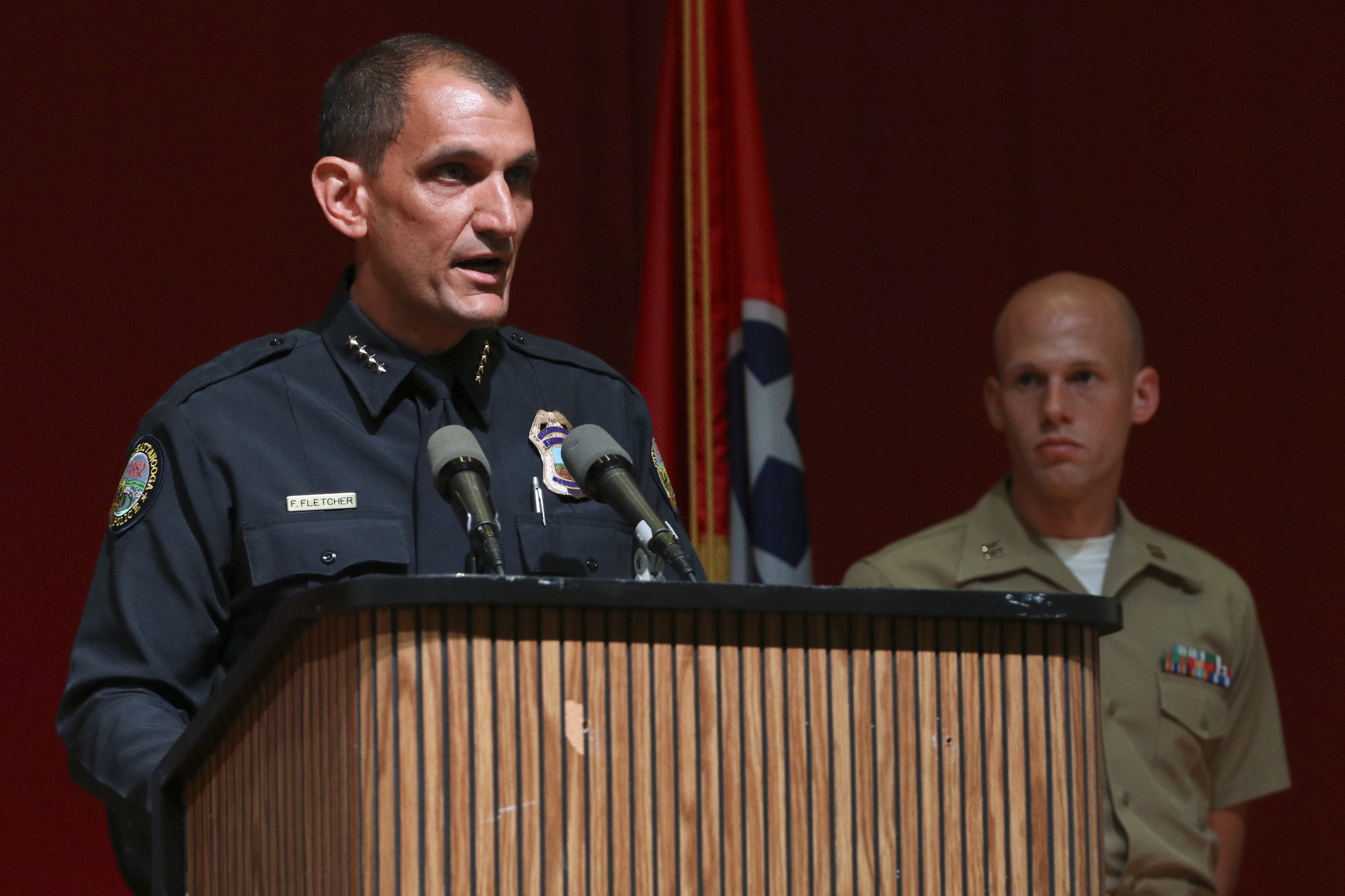 Chattanooga Police Chief Fred Fletcher, left, speaks to media as USMC Captain Ty Balzer listens from behind during a press conference at Tennessee Valley Authority's Missionary Ridge Auditorium on Friday, July 17, 2015 the day after a four Marines were shot and killed. The investigation is being treated as an act of terrorism.