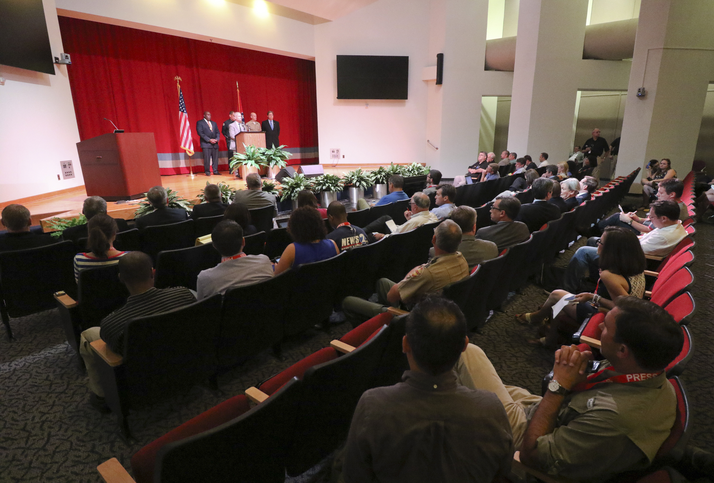 FBI Special Agent Ed Reinhold, center, speaks as media fill the Tennessee Valley Authority's Missionary Ridge Auditorium during a press conference on Friday, July 17, 2015 the day after a four Marines were shot and killed. The investigation is being treated as an act of terrorism.