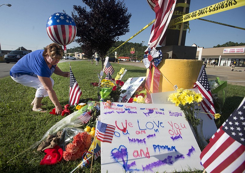 Cathy Sosbee places a balloon and flowers at a makeshift memorial outside a military recruiting center on Friday, July 17, 2015, in Chattanooga. Mohammad Youssef Abdulazeez attacked two military facilities on Thursday, in a shooting rampage that killed four Marines. 