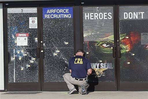 An FBI investigator investigates the scene of a shooting outside a military recruiting center on Friday, July 17, 2015, in Chattanooga, Tenn. Mohammad Youssef Abdulazeez of Hixson, Tenn., attacked two military facilities on Thursday, in a shooting rampage that killed four Marines. (AP Photo/John Bazemore)