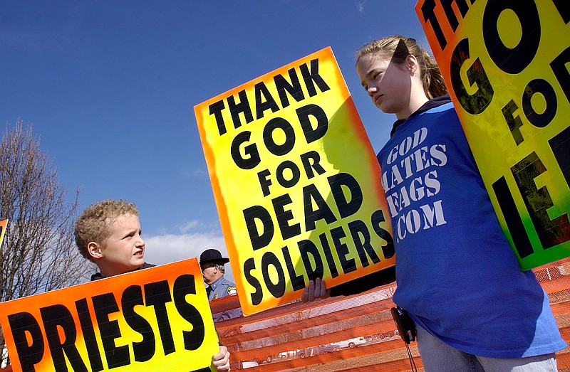 Westboro Baptist church member Gabriel Phelps-Roper, 10, and his sister Grace Phelps-Roper, 13, both of Topeka, Kan., protest at the funeral of Marine Lance Cpl. Matthew A. Snyder in Westminster, Md. 