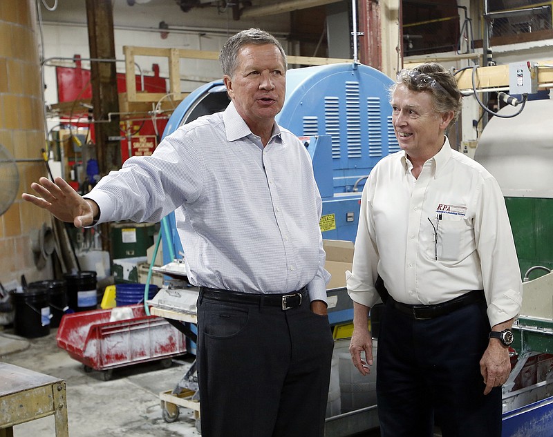 Ohio Gov. John Kasich talks with Joe Shean during a visit at RP Abrasives, last week in Rochester, N.H. Kasich is expected to join the crowded field of candidates seeking the Republican nomination for president. (AP Photo/Jim Cole)