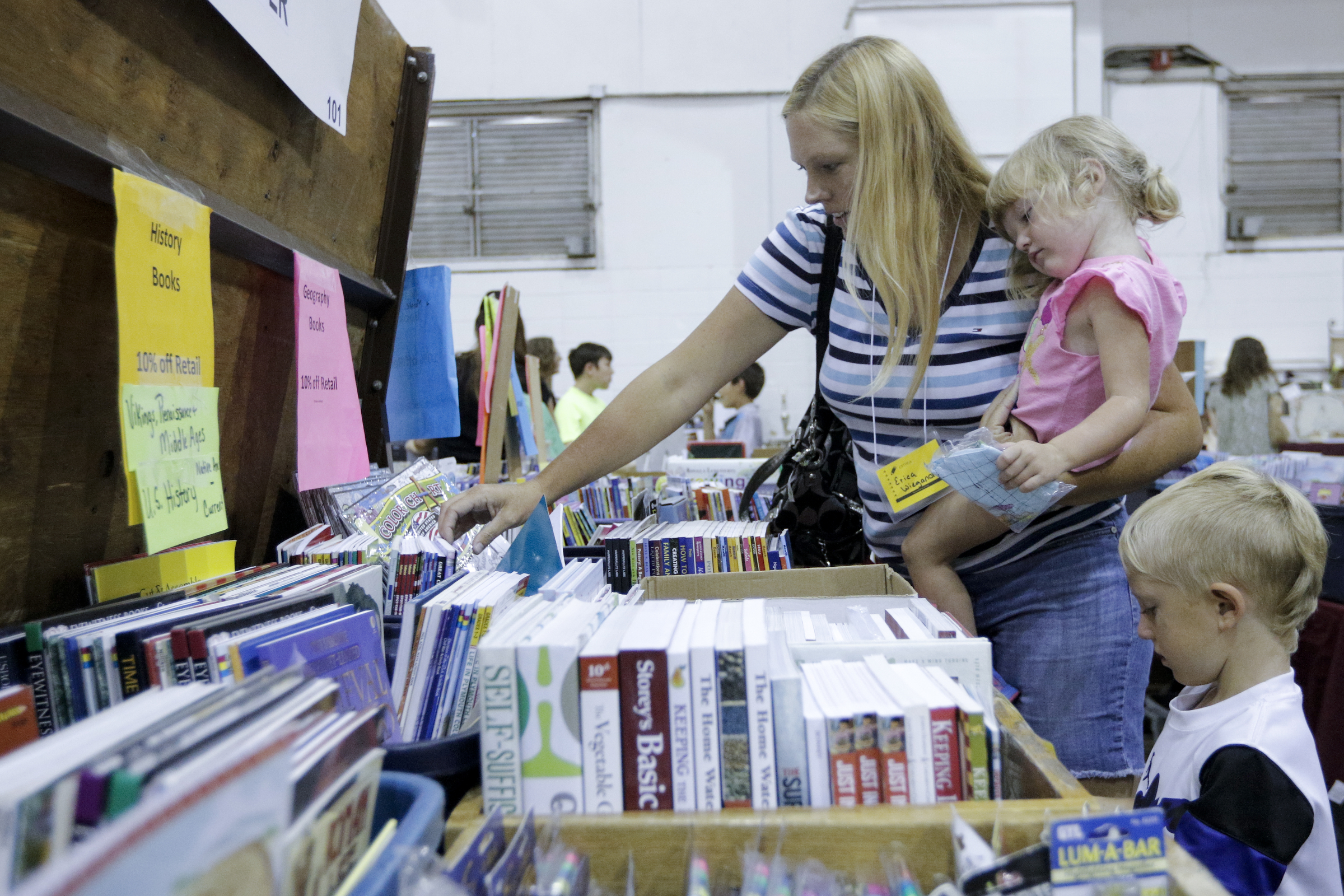 Erica Wiegand holds her daughter Addison as they look with her son Tristin for educational books at the 32nd Annual Education Expo & Homeschool Curriculum Fair on Saturday, July 18, 2015, at Camp Jordan Arena in Chattanooga, Tenn.