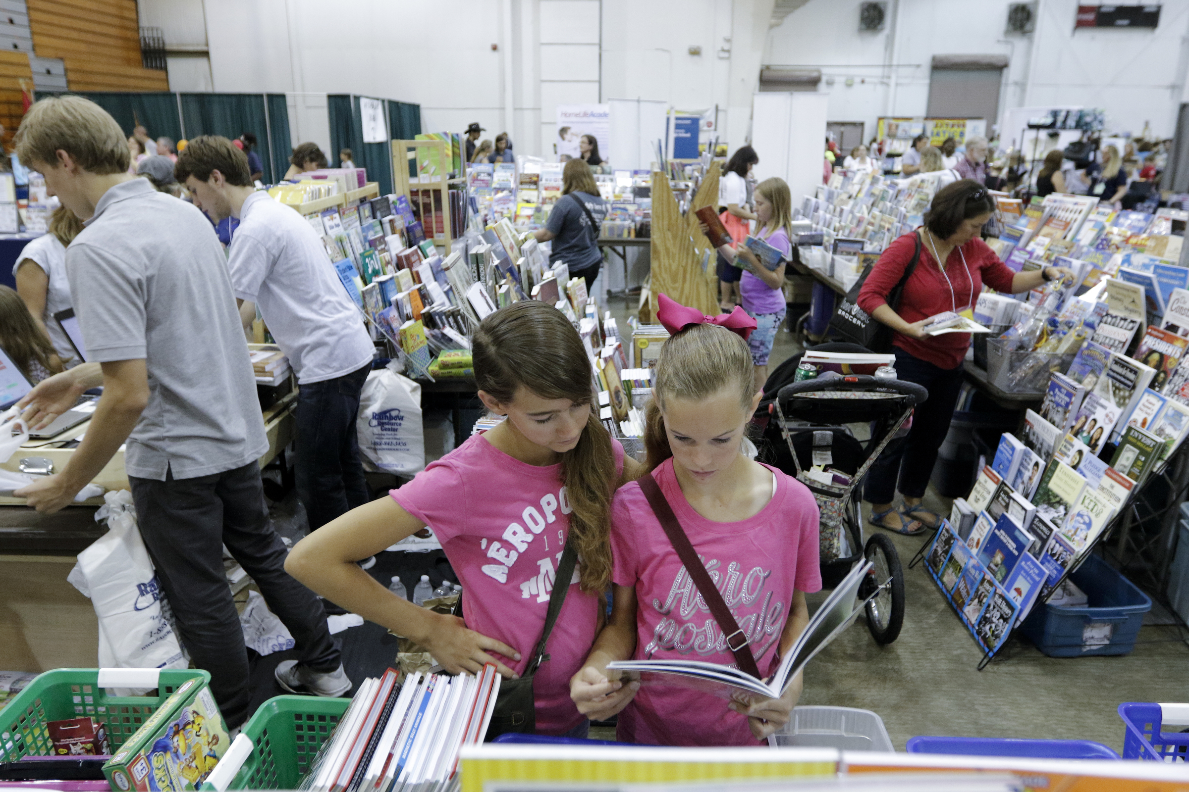 Natalie Halling, right, and her twin sister Kenadie Halling look at a book at the 32nd Annual Education Expo & Homeschool Curriculum Fair on Saturday, July 18, 2015, at Camp Jordan Arena in Chattanooga, Tenn.